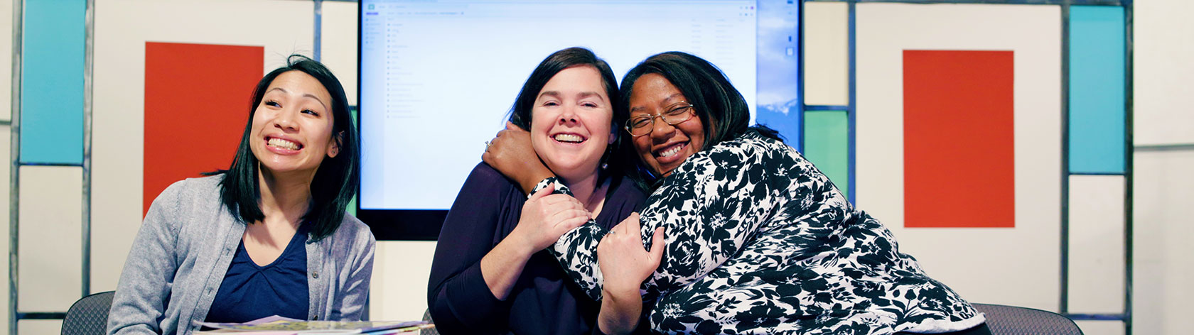 The three hosts of Circle Time Magazine smilling, hugging, and having fun on the set