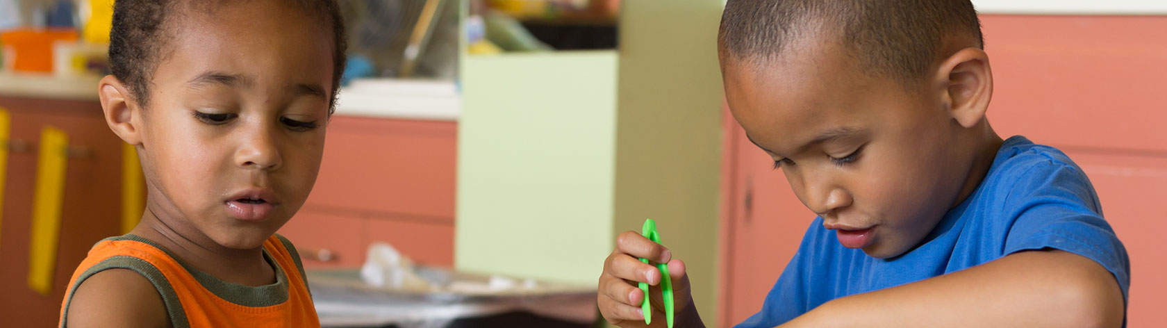 Two elementary students counting items with plastic green tweesers