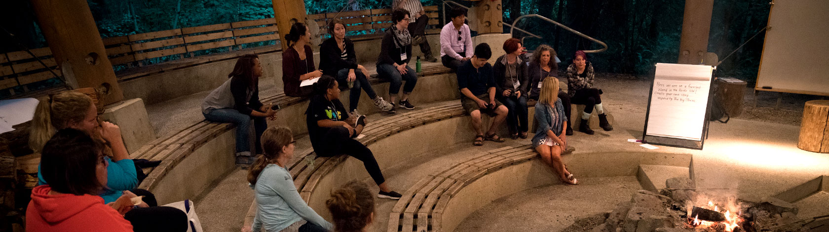 Attendees gathered around a camp fire, sharing