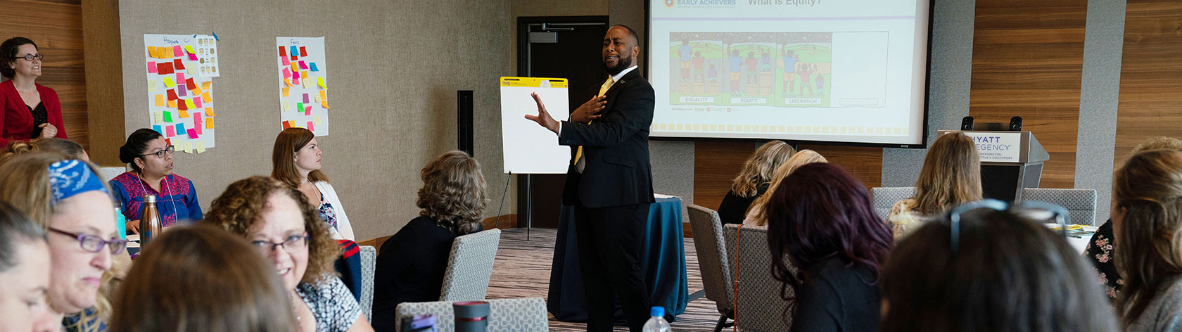 Speaker presenting to a room of attendees