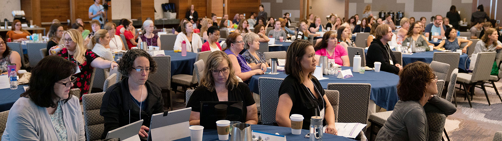 A room of attentive attendees listening to a presenter