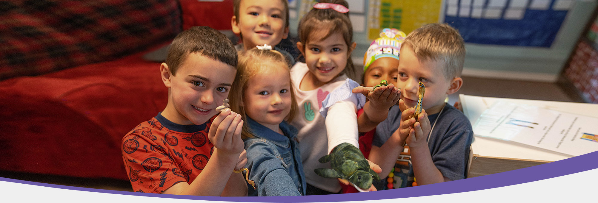 6 children smiling and holding their toys up 6 children smiling and holding their toys up