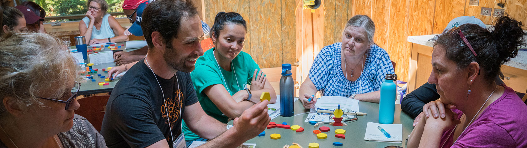 Attendees doing a hands on activitiy with shapes together at a table